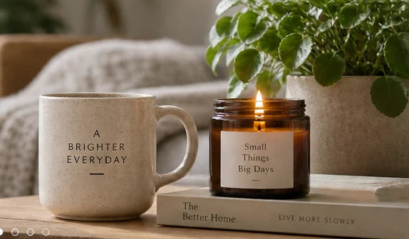 An illustrative still life of a ceramic mug and candle in a calm living space